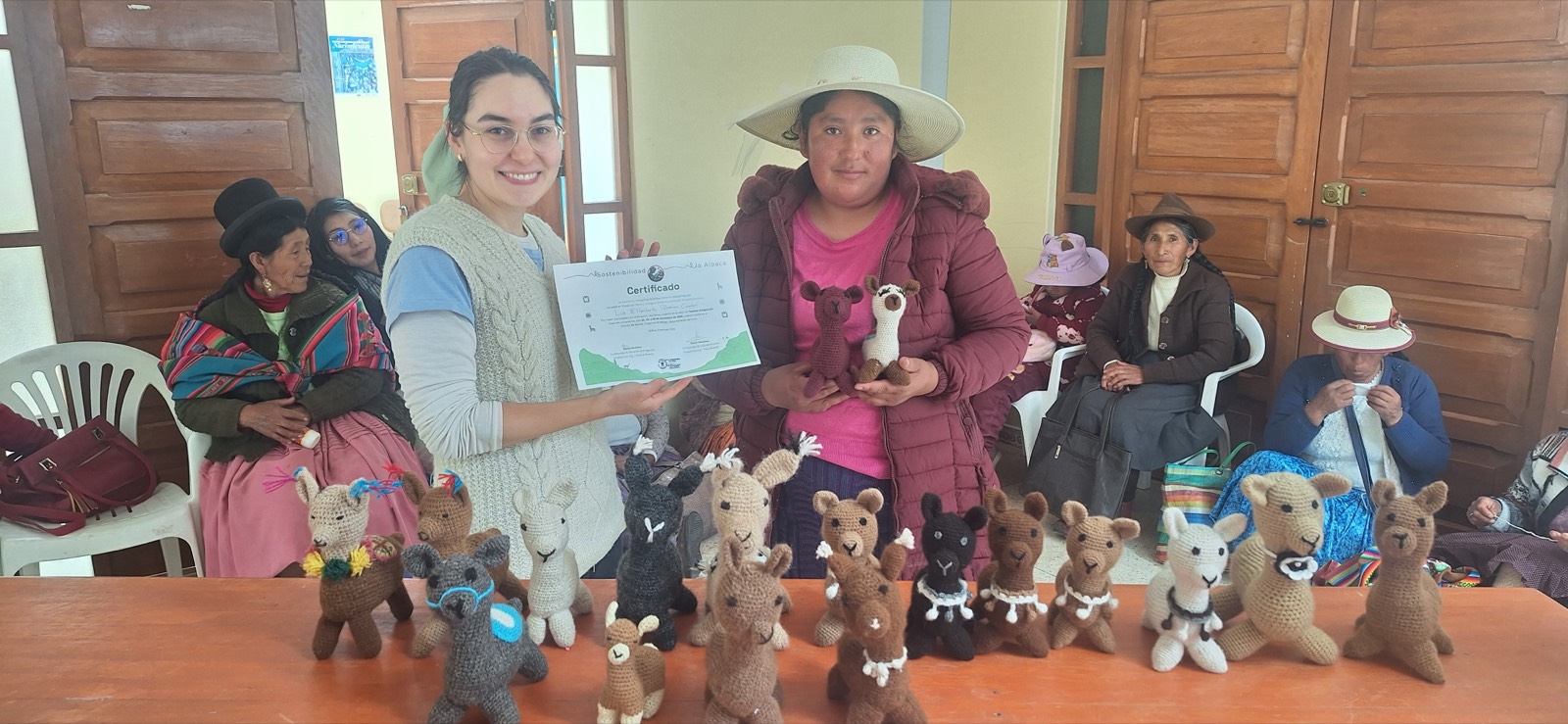 An artisan receiving her workshop certificate while holding two amigurumi she crocheted